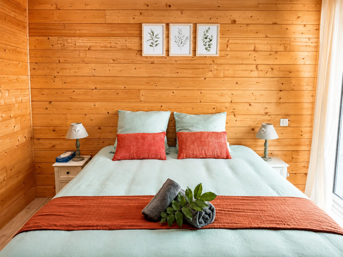 Chambre verte en bois avec lit queen size et lumière naturelle