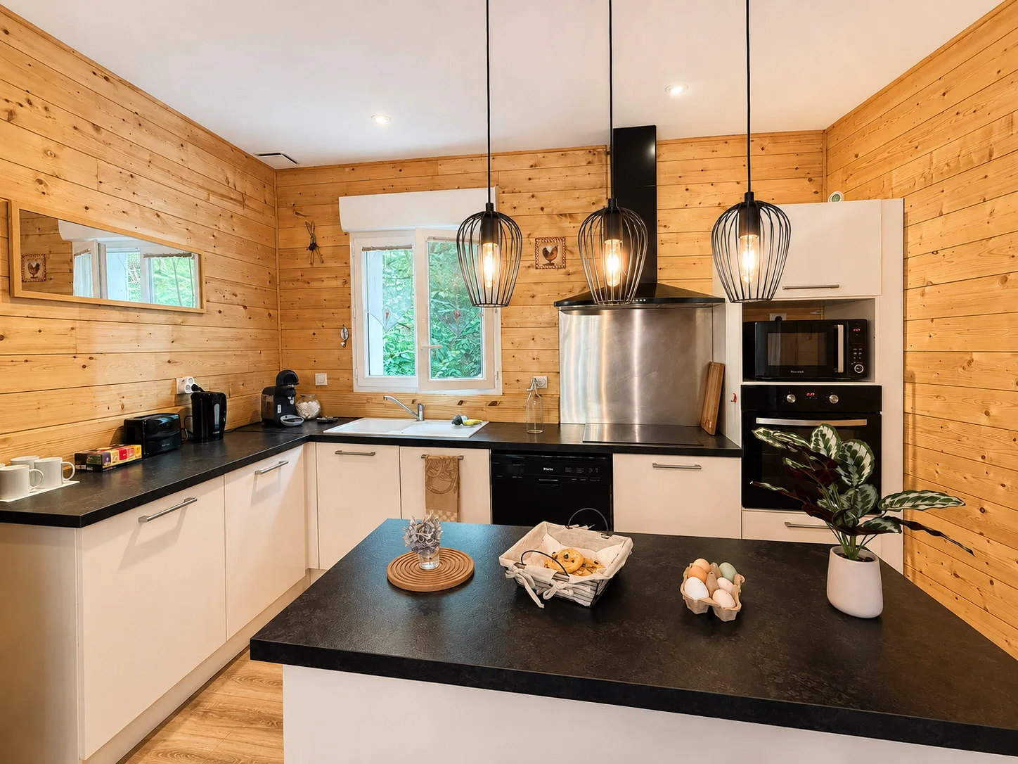 Cuisine équipée avec îlot, réfrigérateur, four et plaques de cuisson