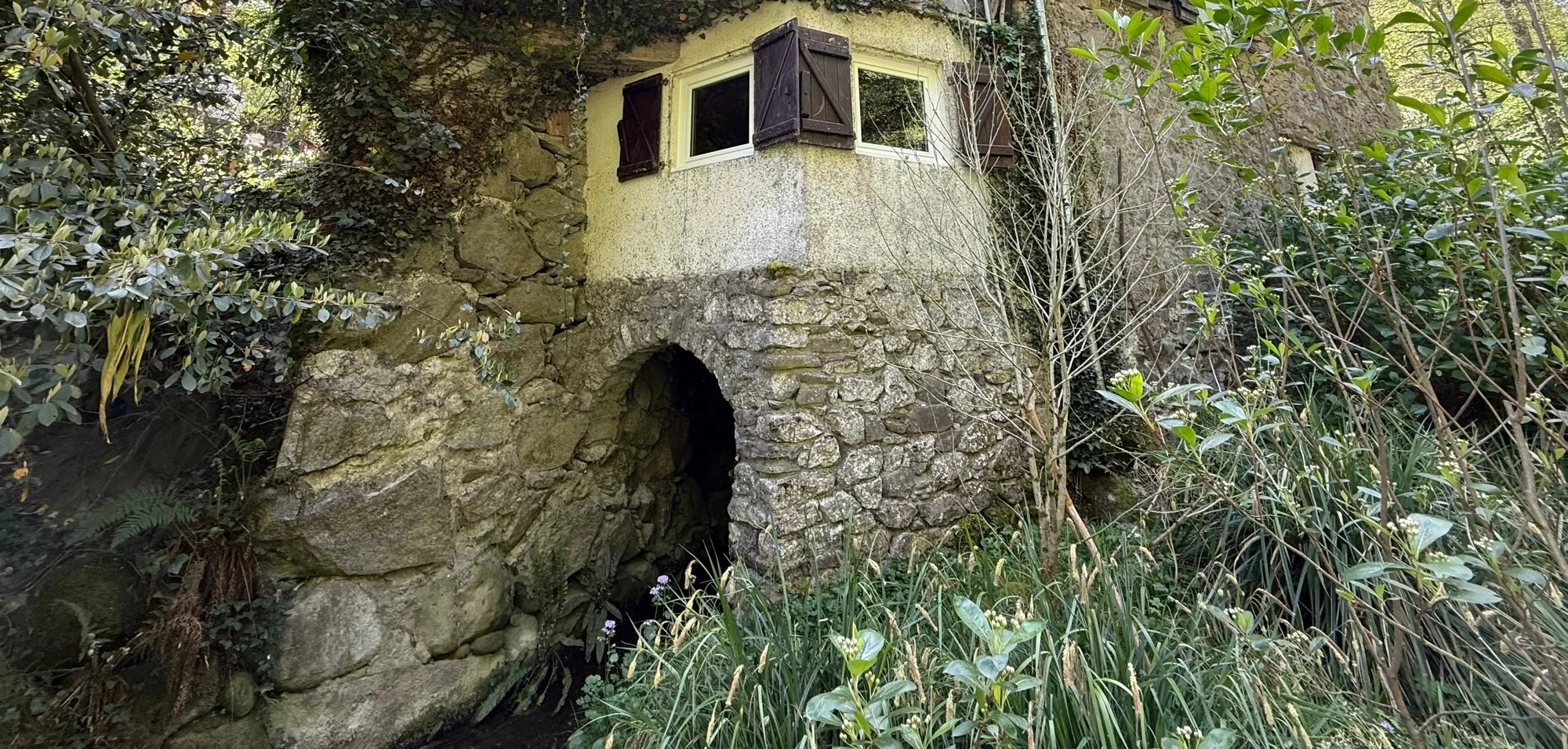 Bâtiment de pierre abritant le laboratoire artisanal dans la partie privée d’Au Moulin