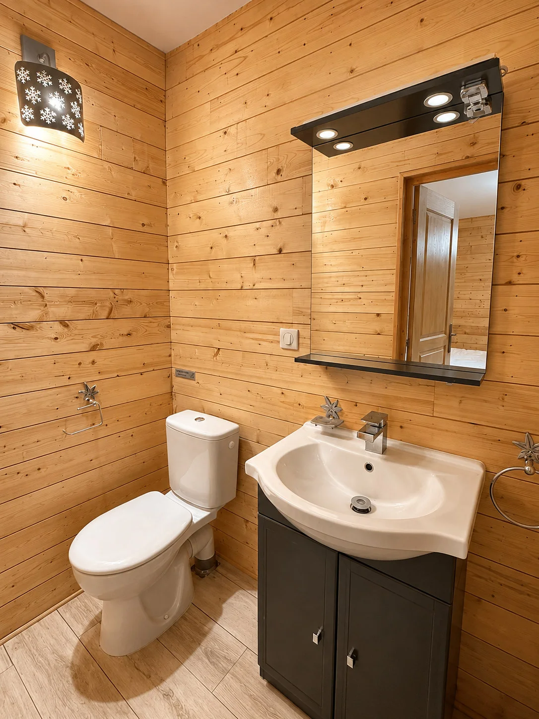 Salle d’eau privative en bois avec vasque, miroir et toilettes