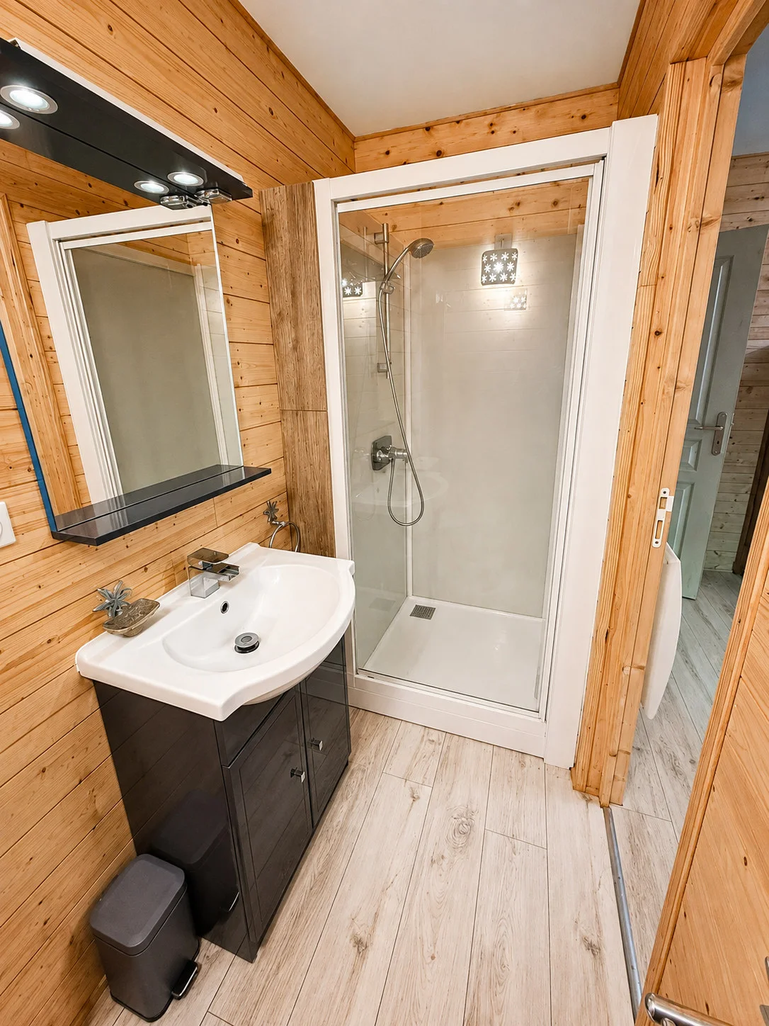 Douche, vasque et bois clair dans la chambre rouge