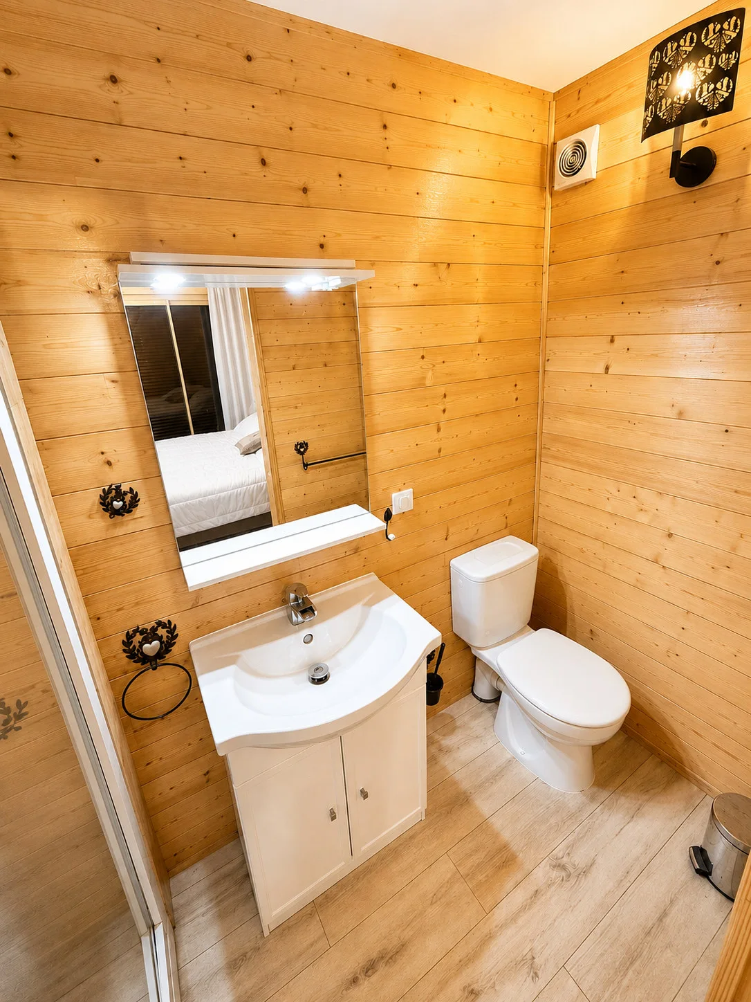 Salle d’eau privative en bois avec vasque et miroir éclairé