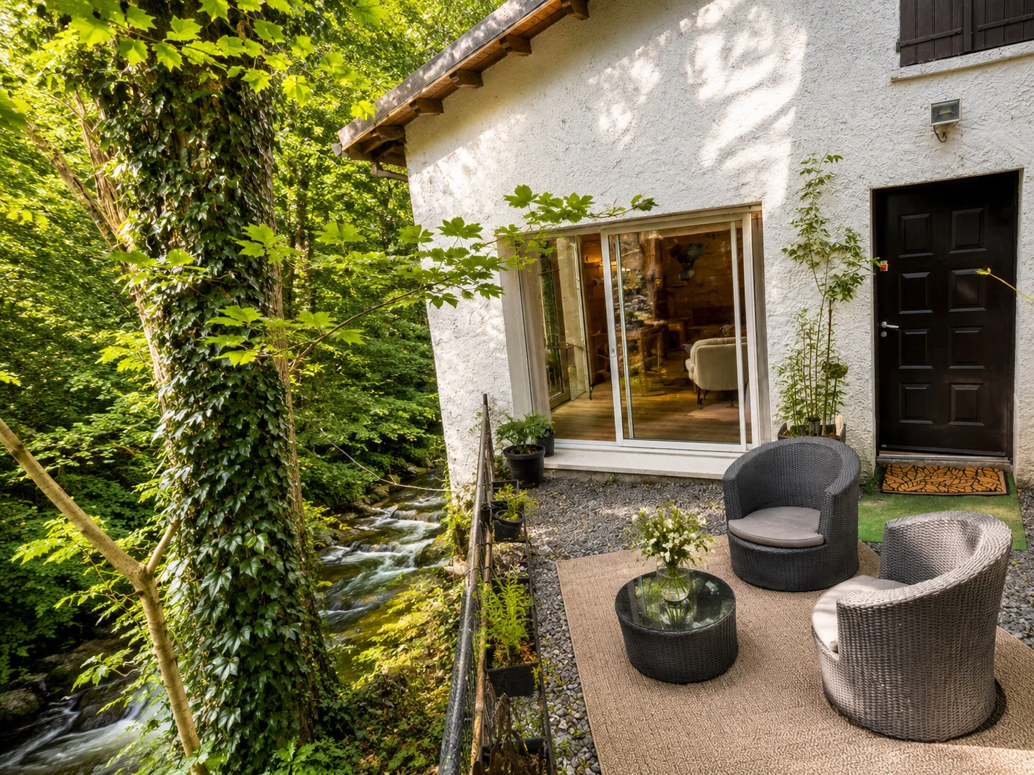 Salon extérieur installé contre le gîte, à quelques pas de la rivière