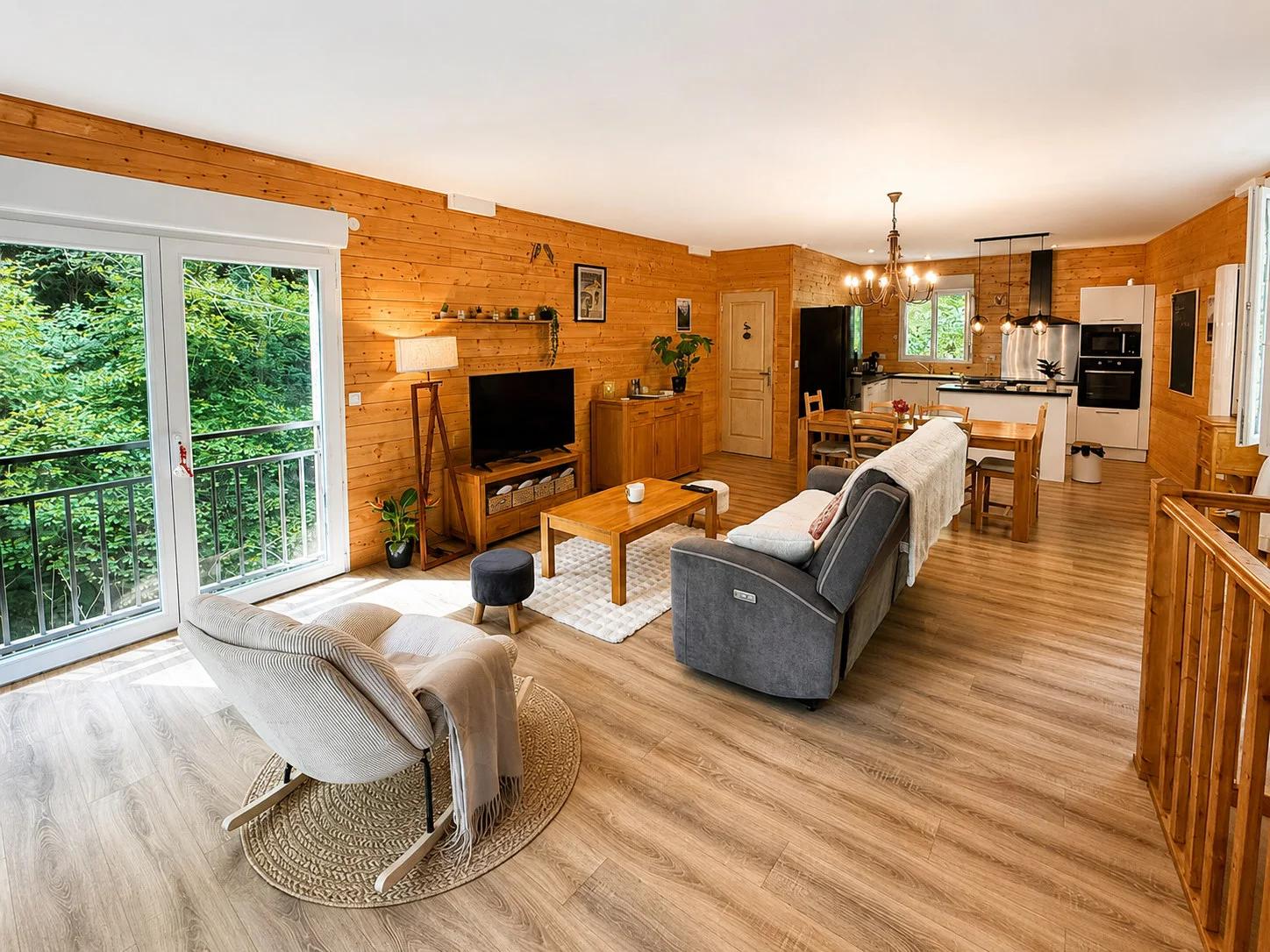 Pièce de vie en bois réunissant salon, grande table et cuisine ouverte