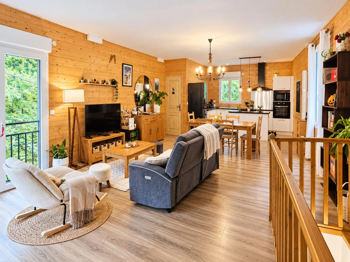Salon, table et cuisine réunis sous le bois clair